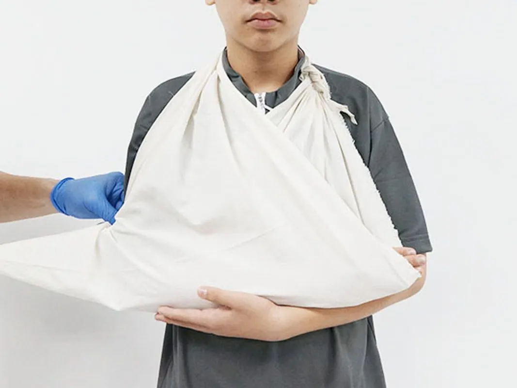 First aider applying an arm sling during Standard First Aid training